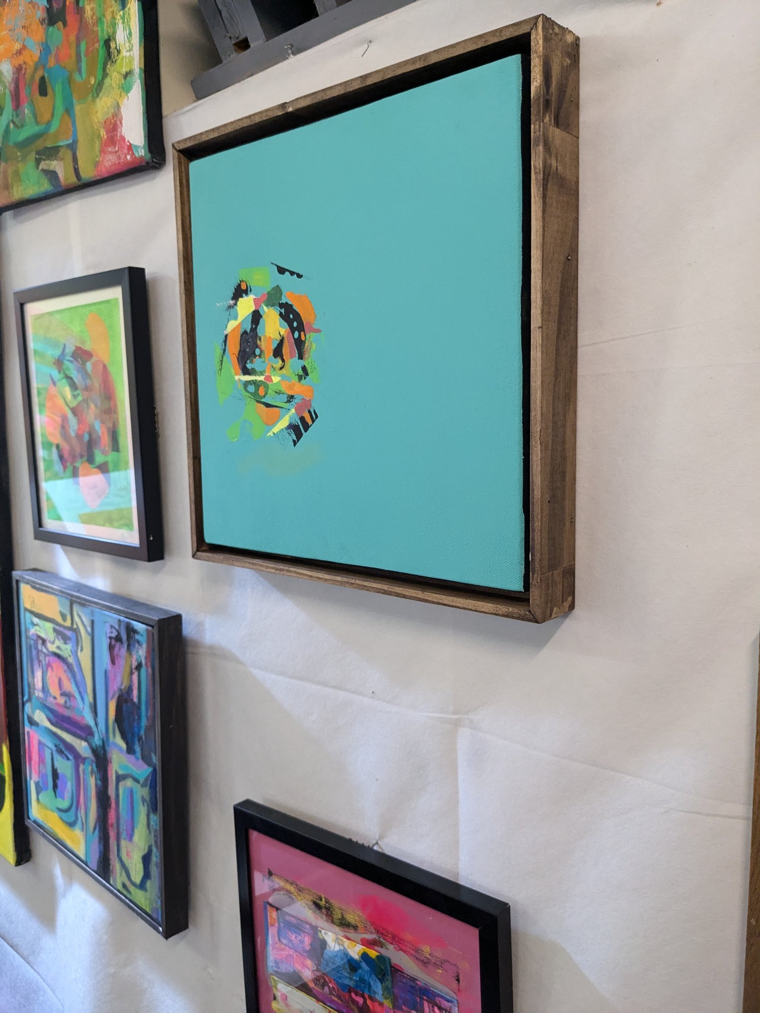 Jordan Dolman's paintings hanging on a gallery wall