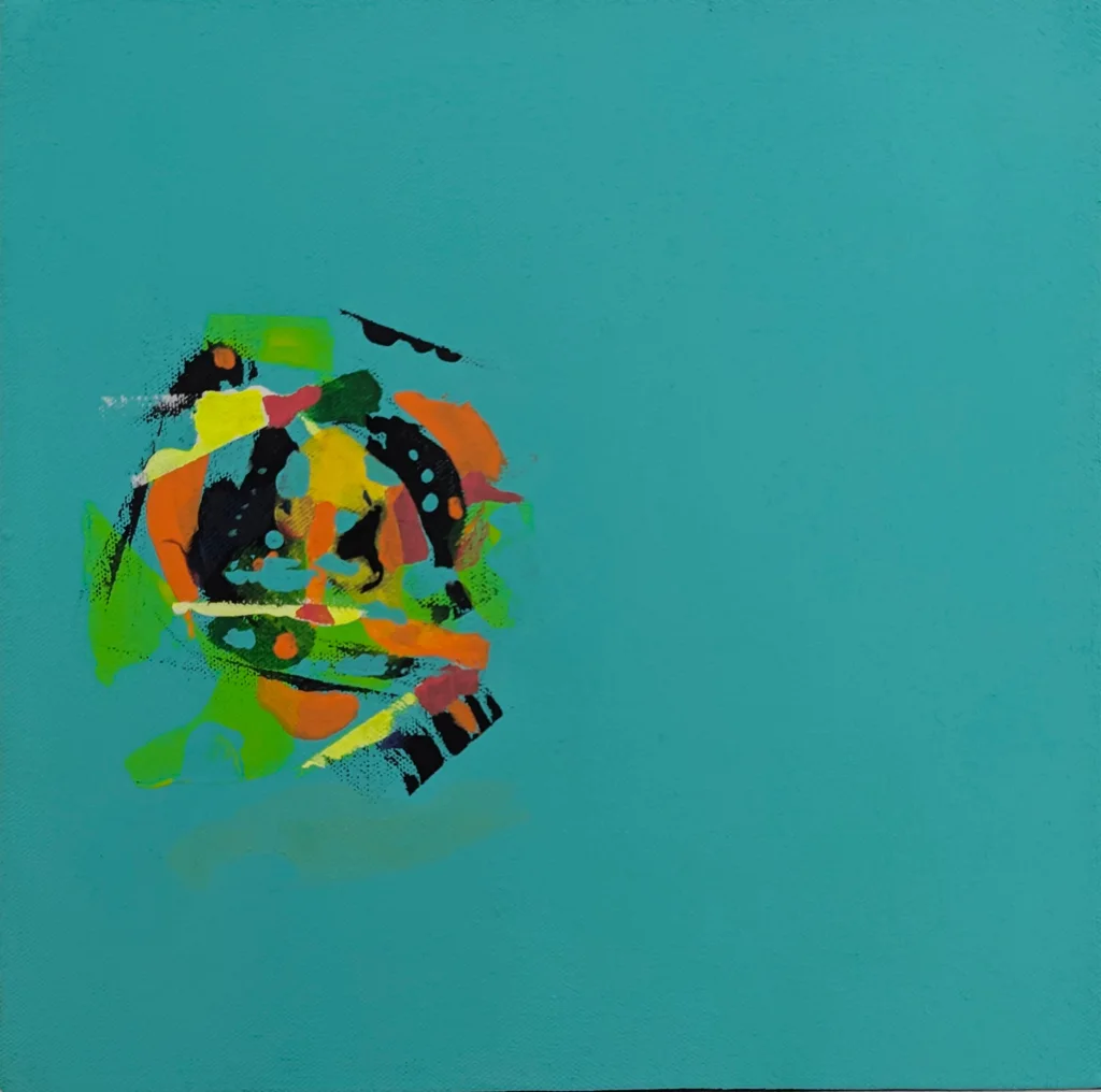 A flat mid-blue canvas holds one small explosion of paint off to the left — a cluster of orange, green, yellow, and