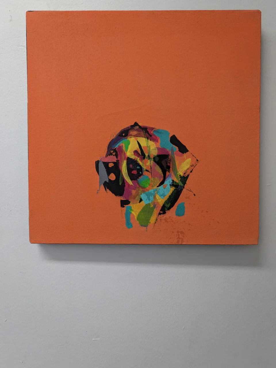 A small burst of color sits at the center of a big flat field of orange. The ground is a warm, even orange that fills