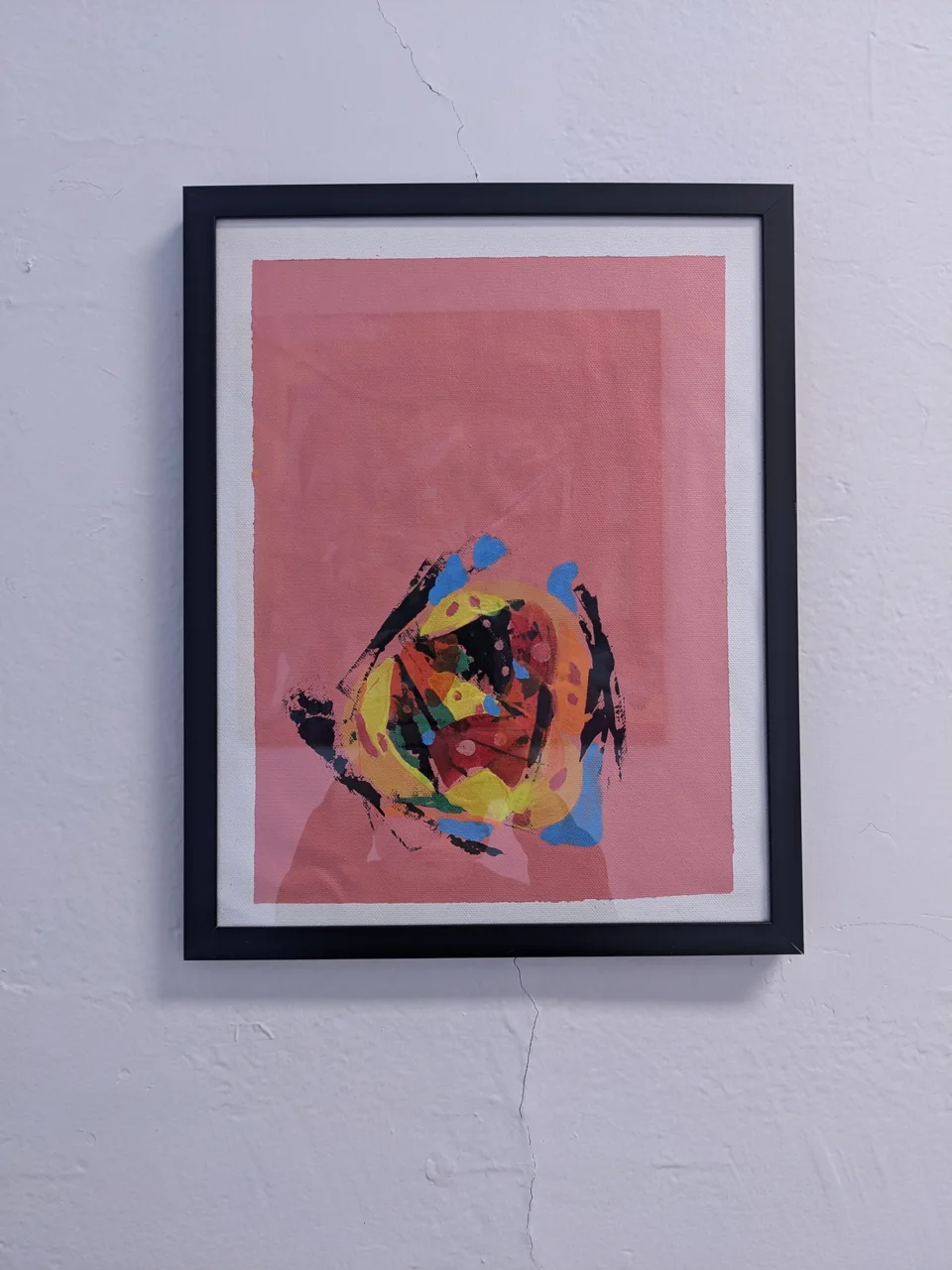 The piece sits in a thin black frame with a white margin around a soft pink ground. Almost all the paint lives in the
